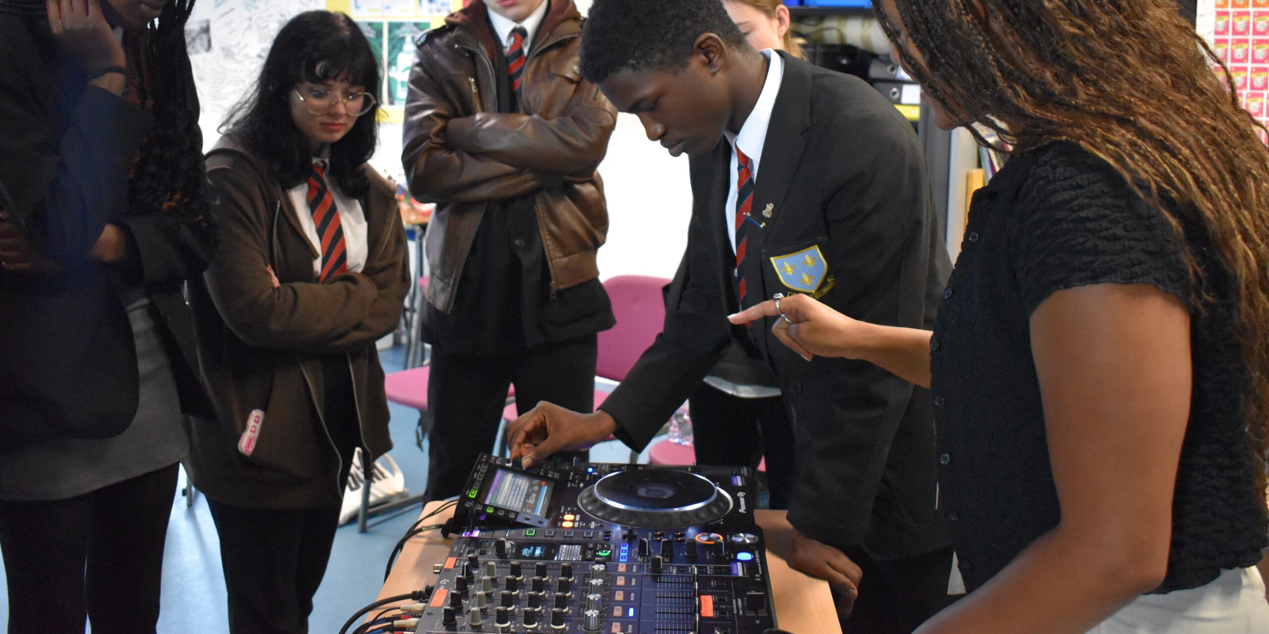 Students gathered around a DJ mixer