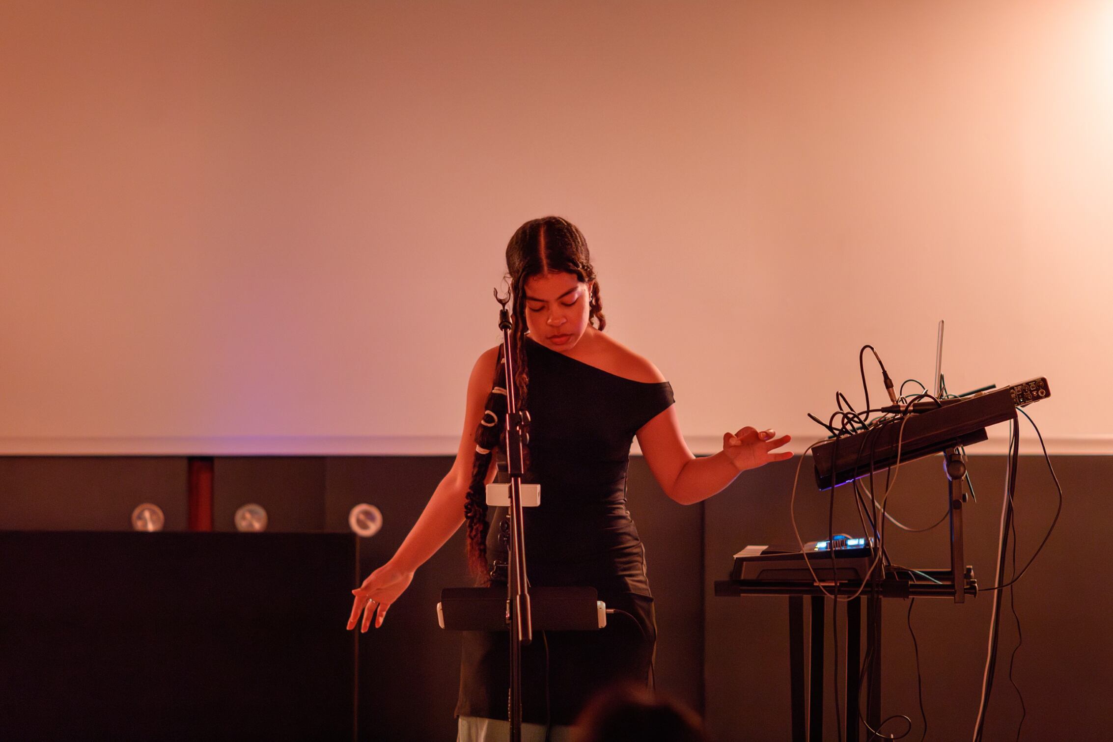 A young electronic musician woman of colour performing in a museum
