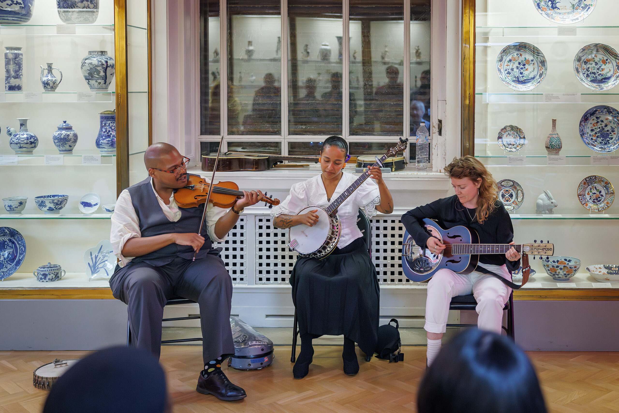 Three folk musicians perform in a museum gallery