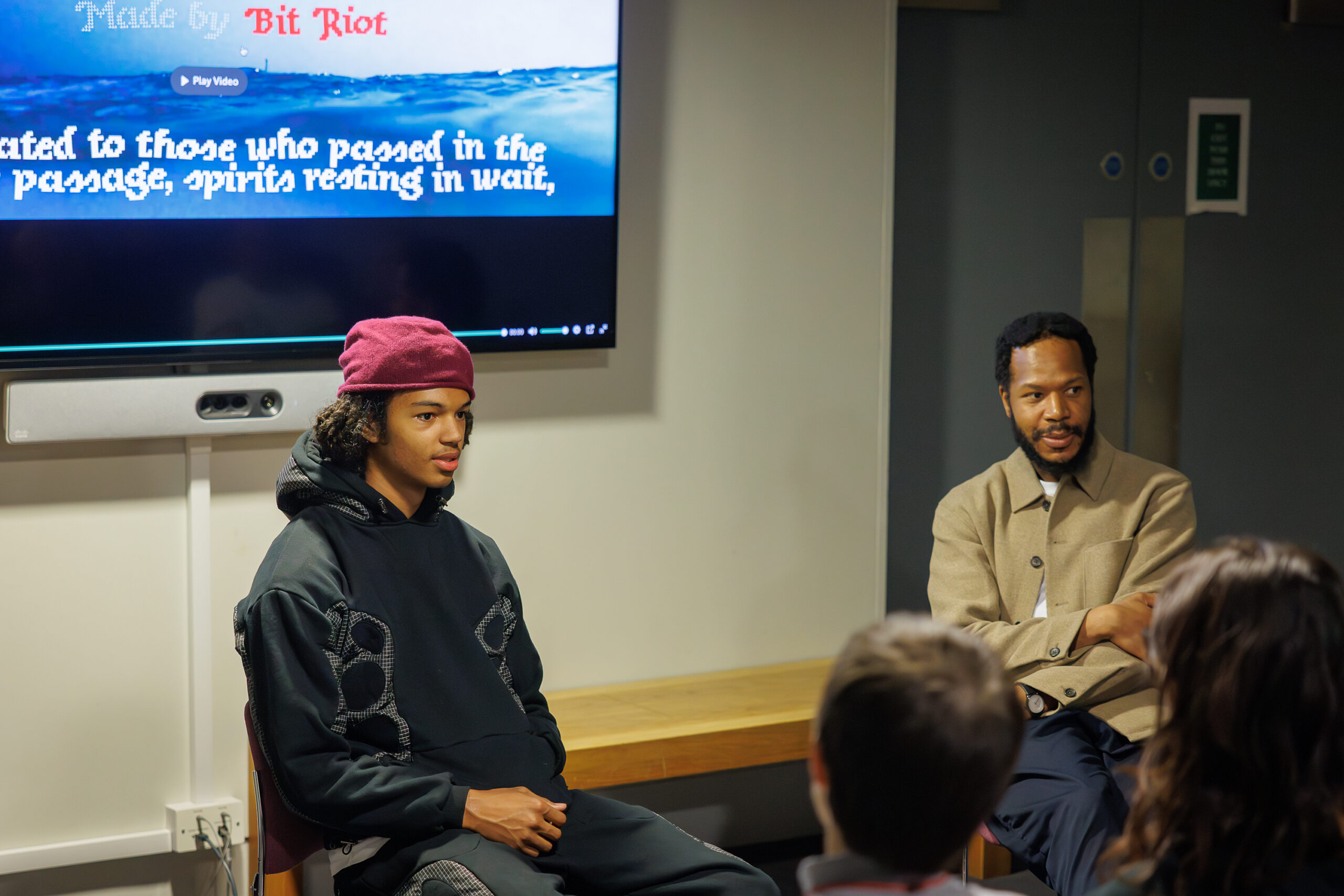 Two young men of colour discuss film for a museum talk