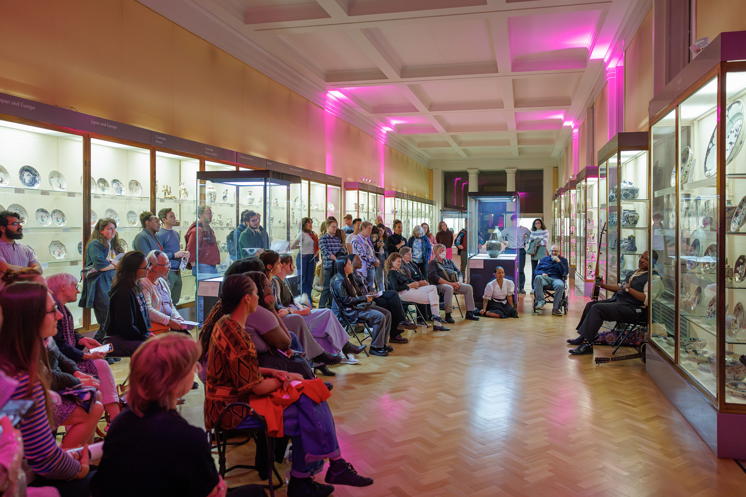 A crowd watching a folk musician perform.