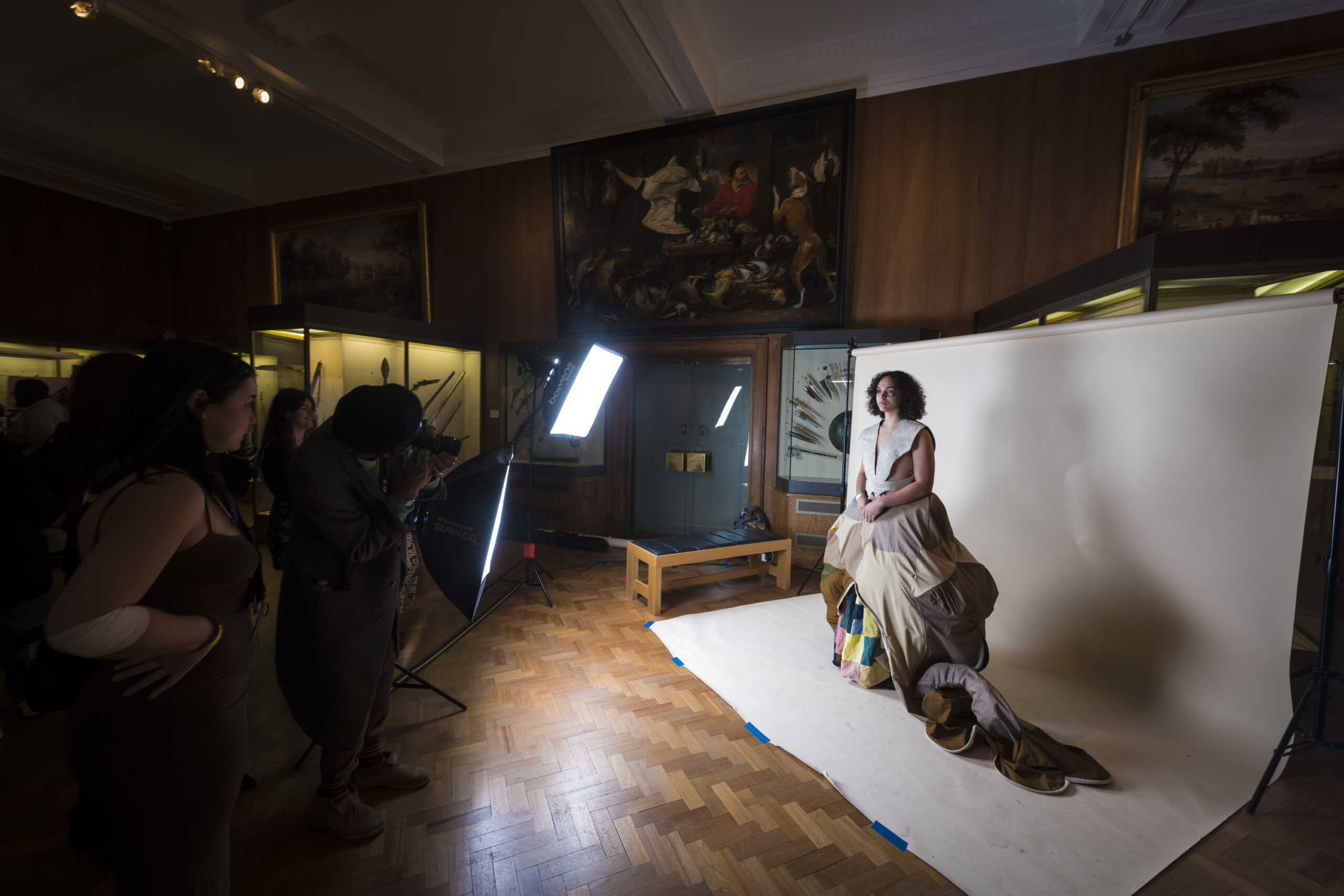 A young person of colour spotlight for a photoshoot in a museum