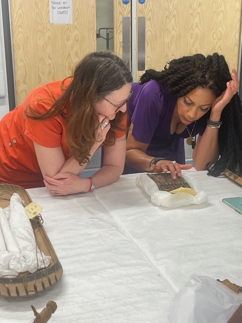 Two women examine an mbira