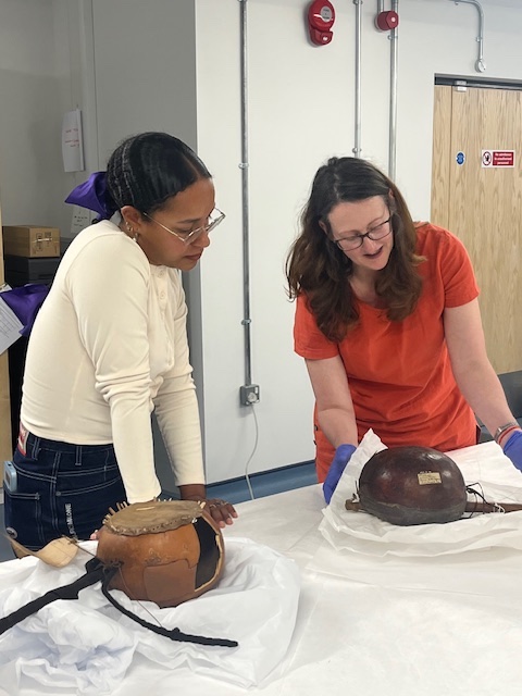 Two women examine Afro-indigenous stringed instruments